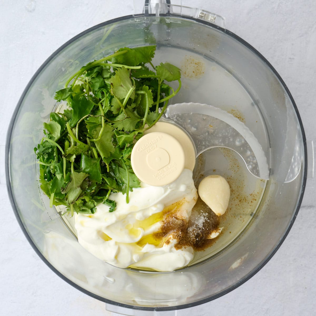Dressing ingredients in a food processor before processing.