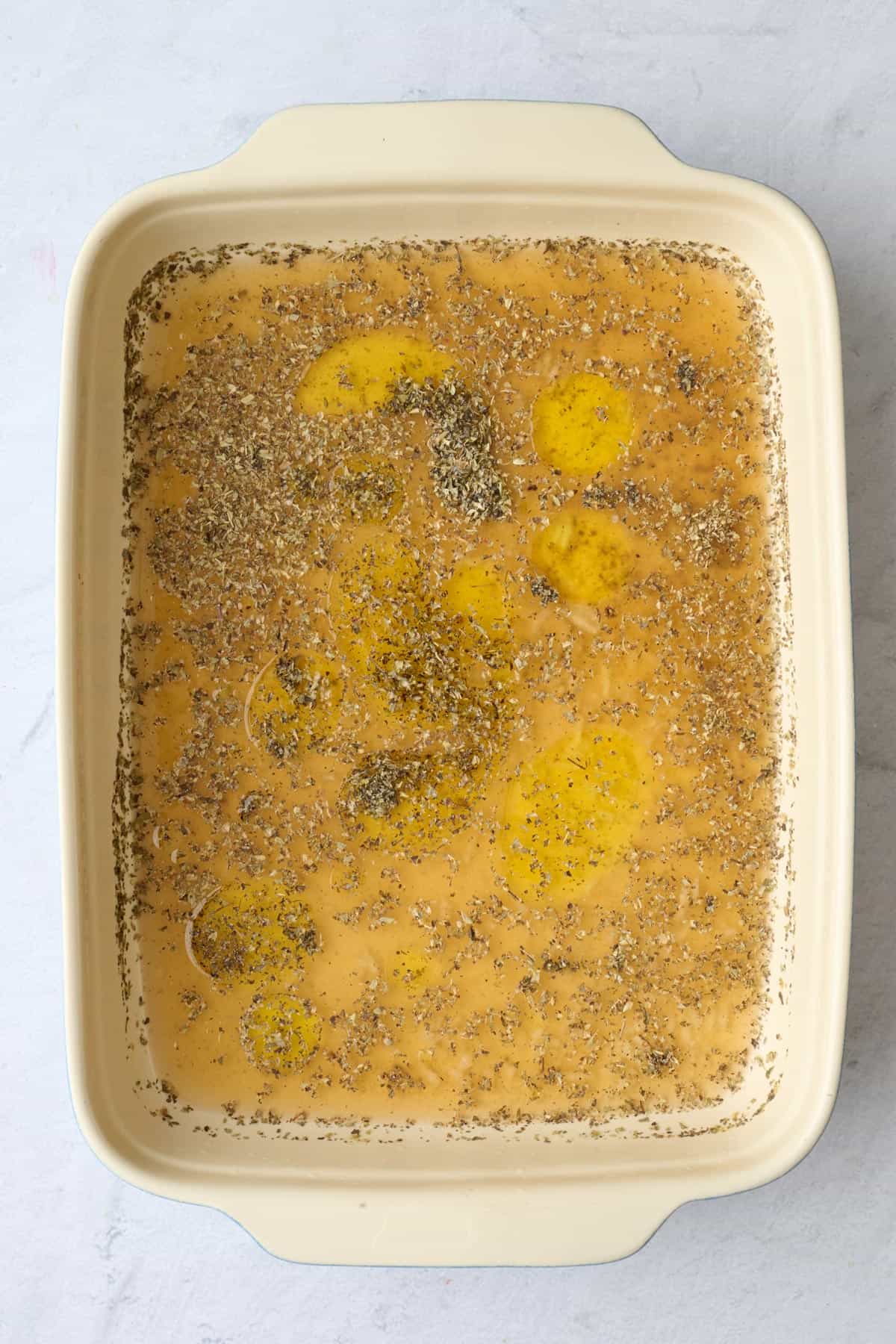 Broth, oil, lemon juice and seasonings in baking dish.