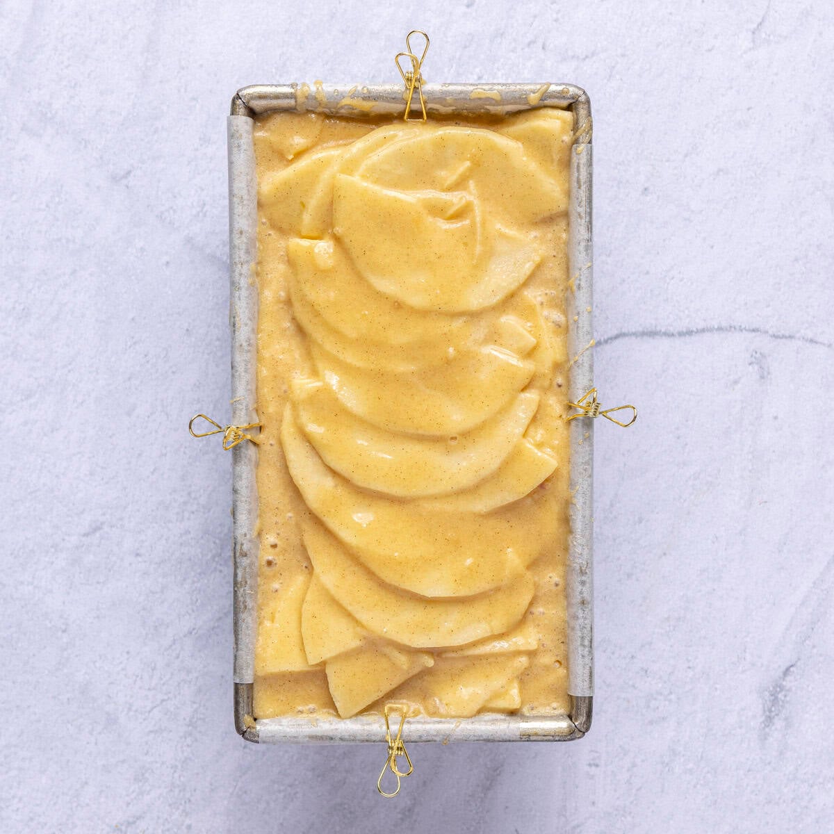 After all apples are added with the reserved apples slices fanned out on top and remaining batter poured over.