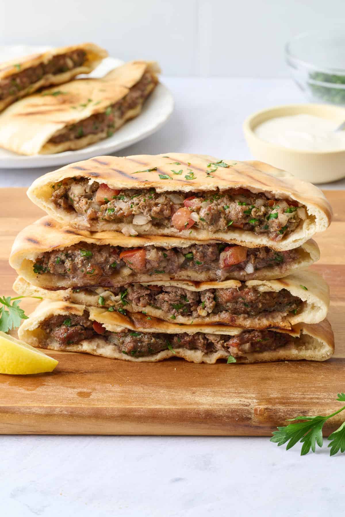 Arayes stacked up on a cutting board showing the ground beef filling.