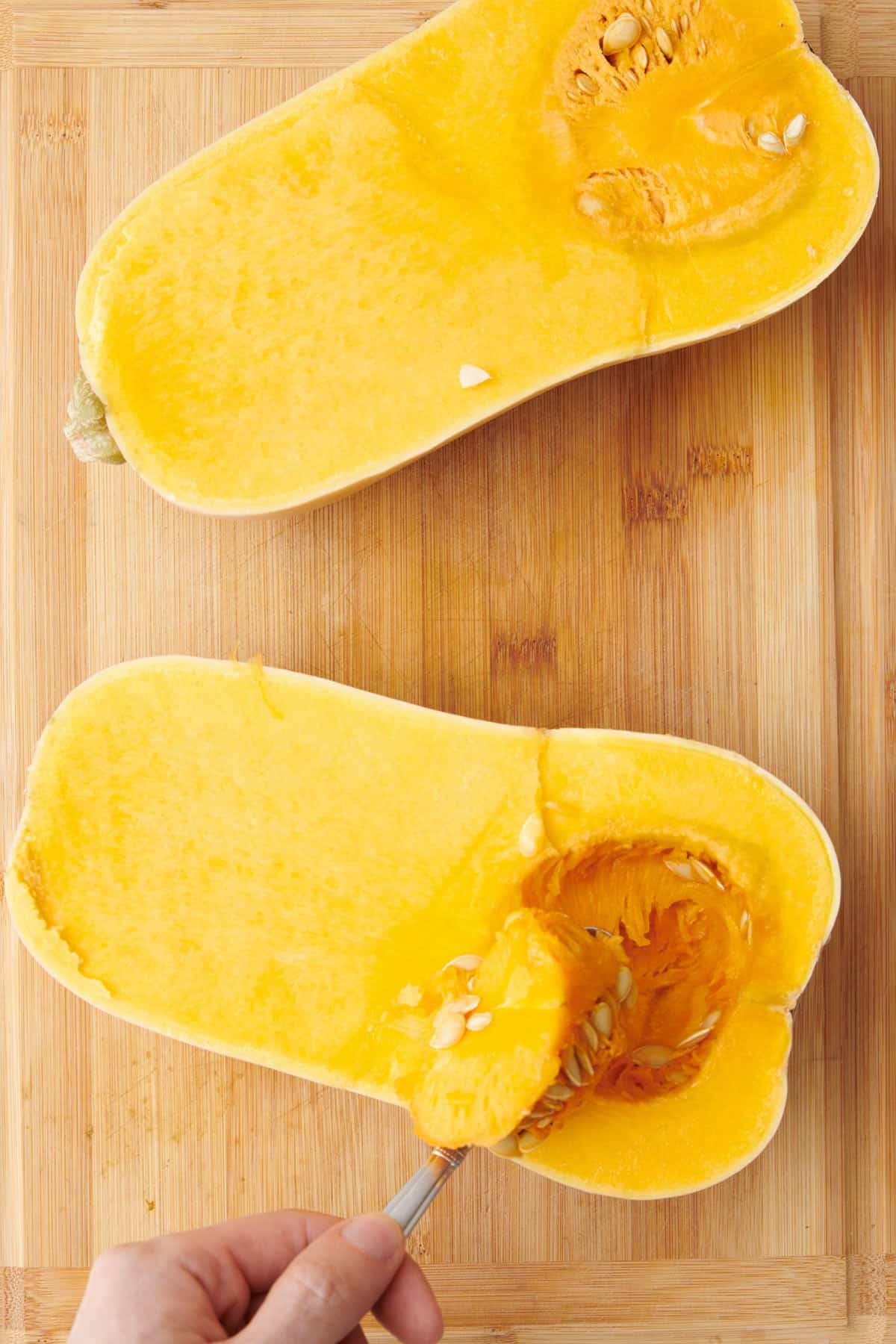 Scooping pulp and seeds from squash.