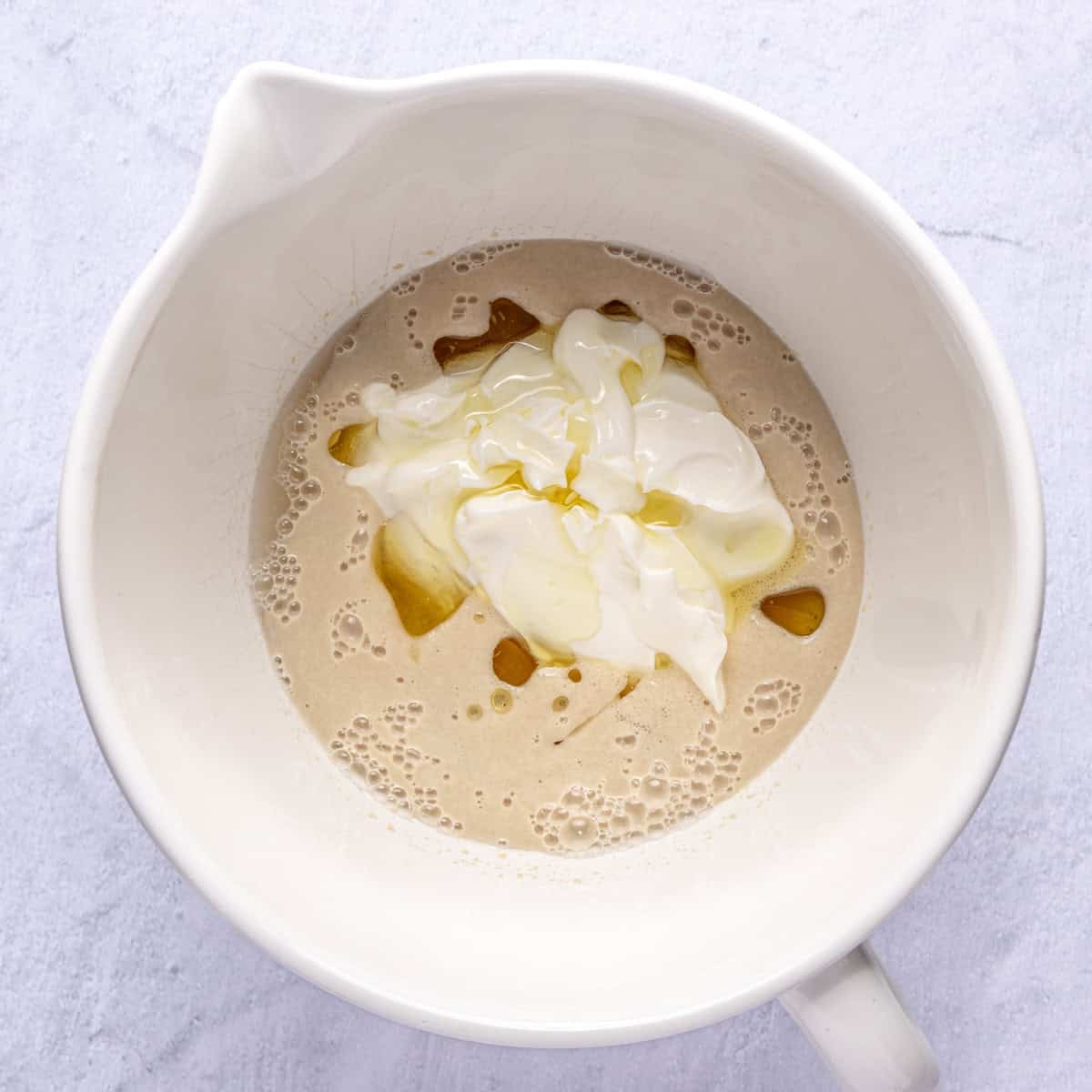 Water, sugar and yeast in a large bowl after foamy with yogurt and oil added.