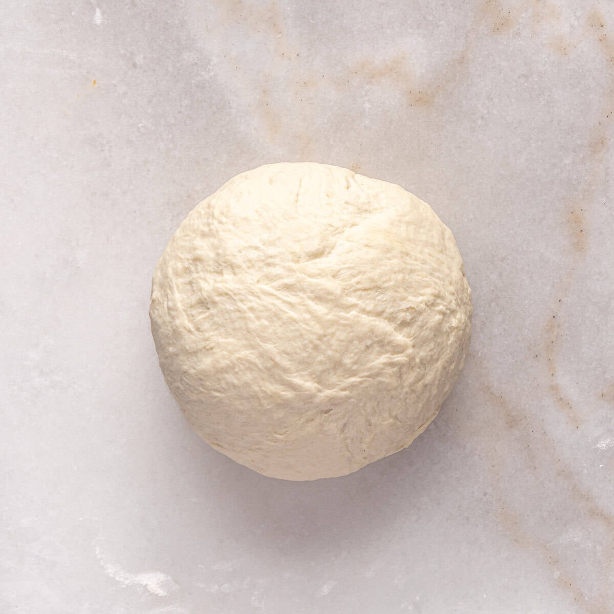 Dough on lightly floured surface after kneading into a smooth ball.