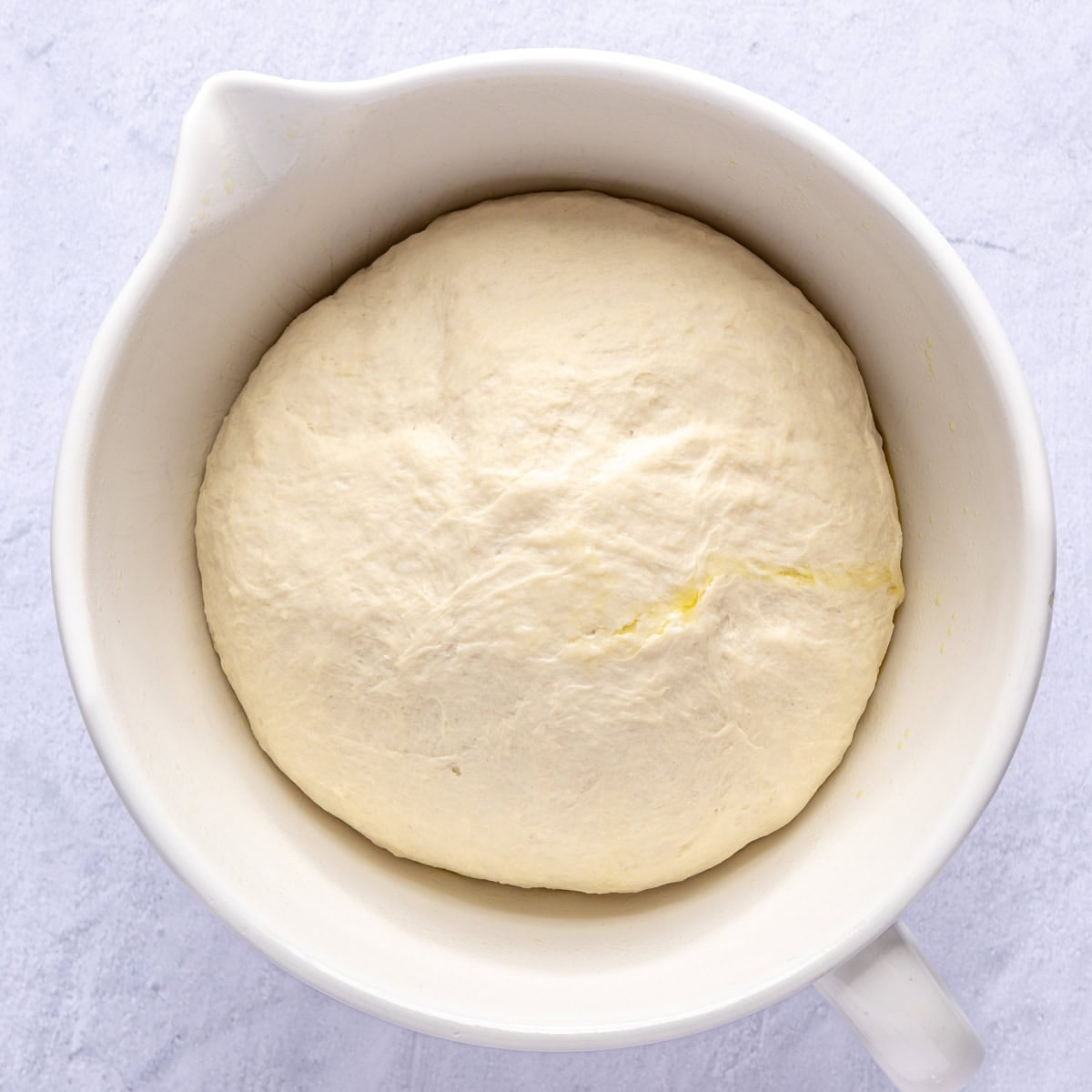 Dough ball in an oiled bowl after rising.