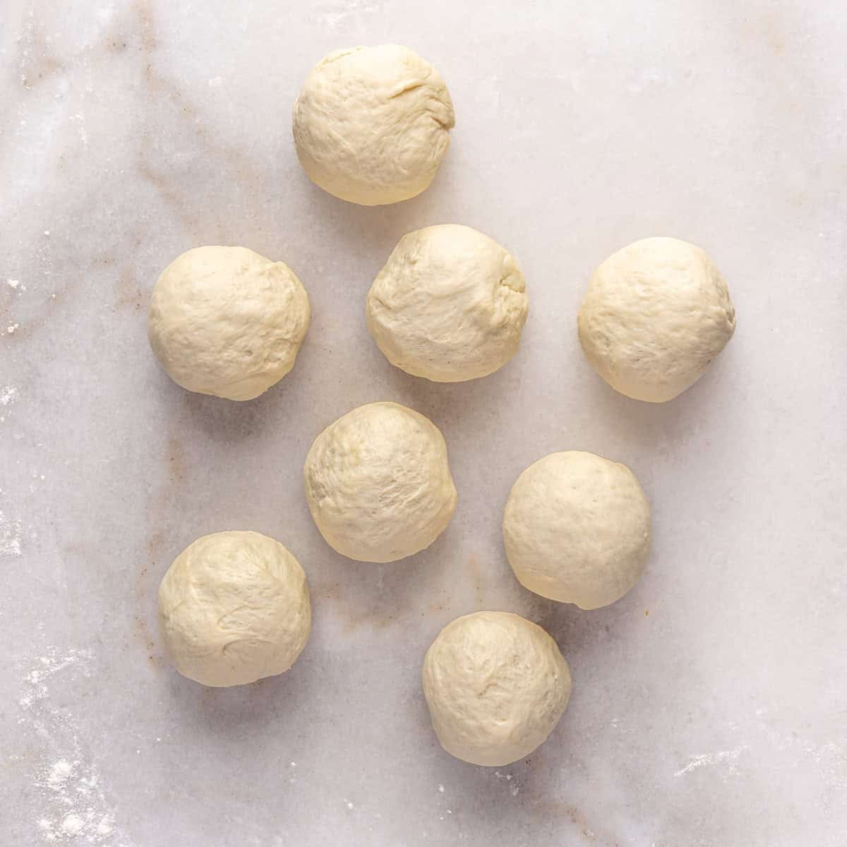 Dough on surface divided into 8 equal pieces.