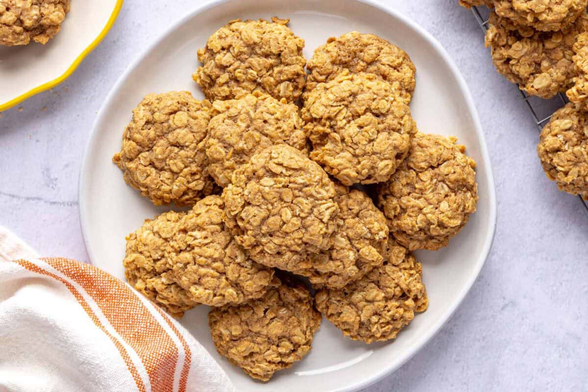 Chewy pumpkin oatmeal cookies on a plate with more nearby.