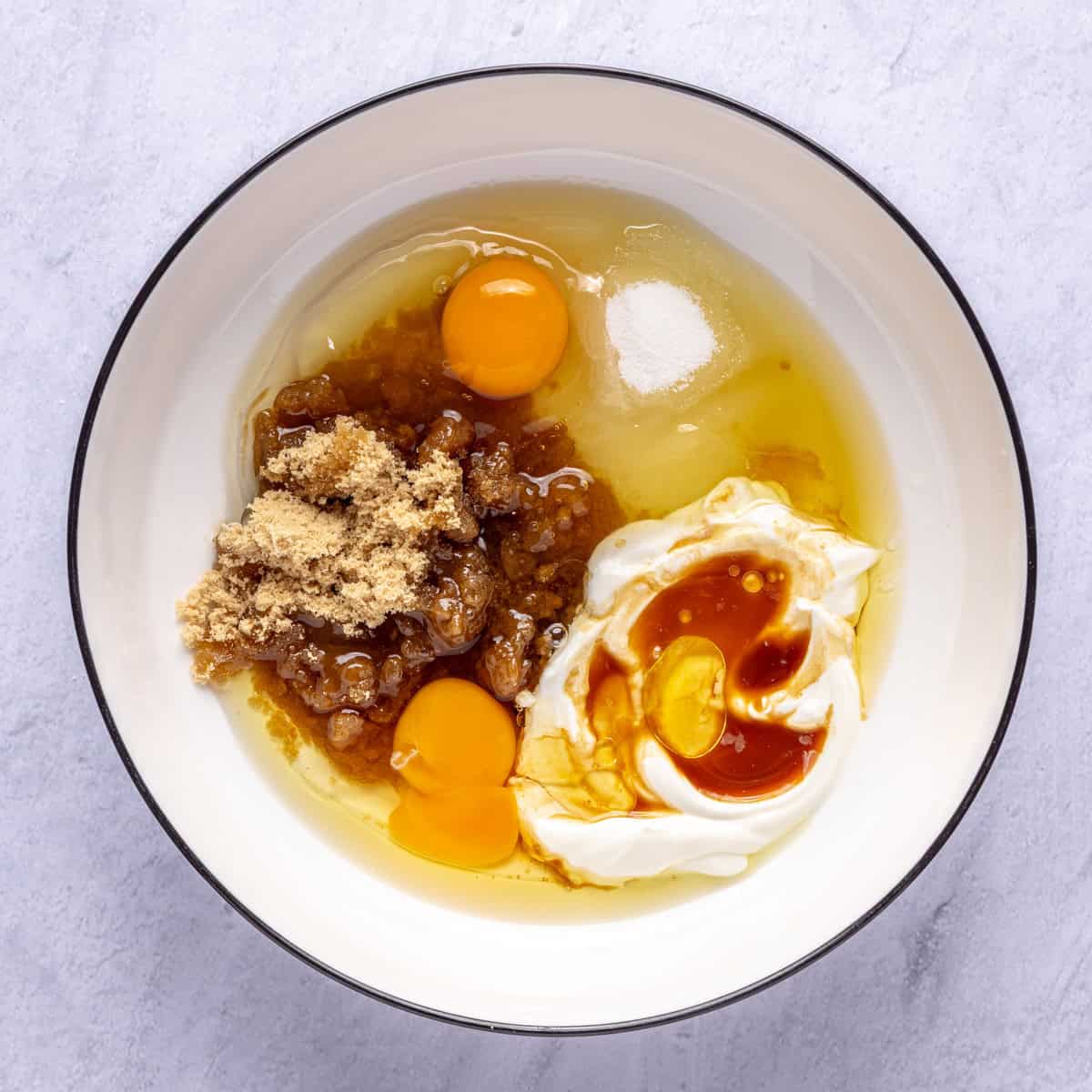 Both sugars, yogurt, oil, eggs and vanilla in a large bowl before mixing.