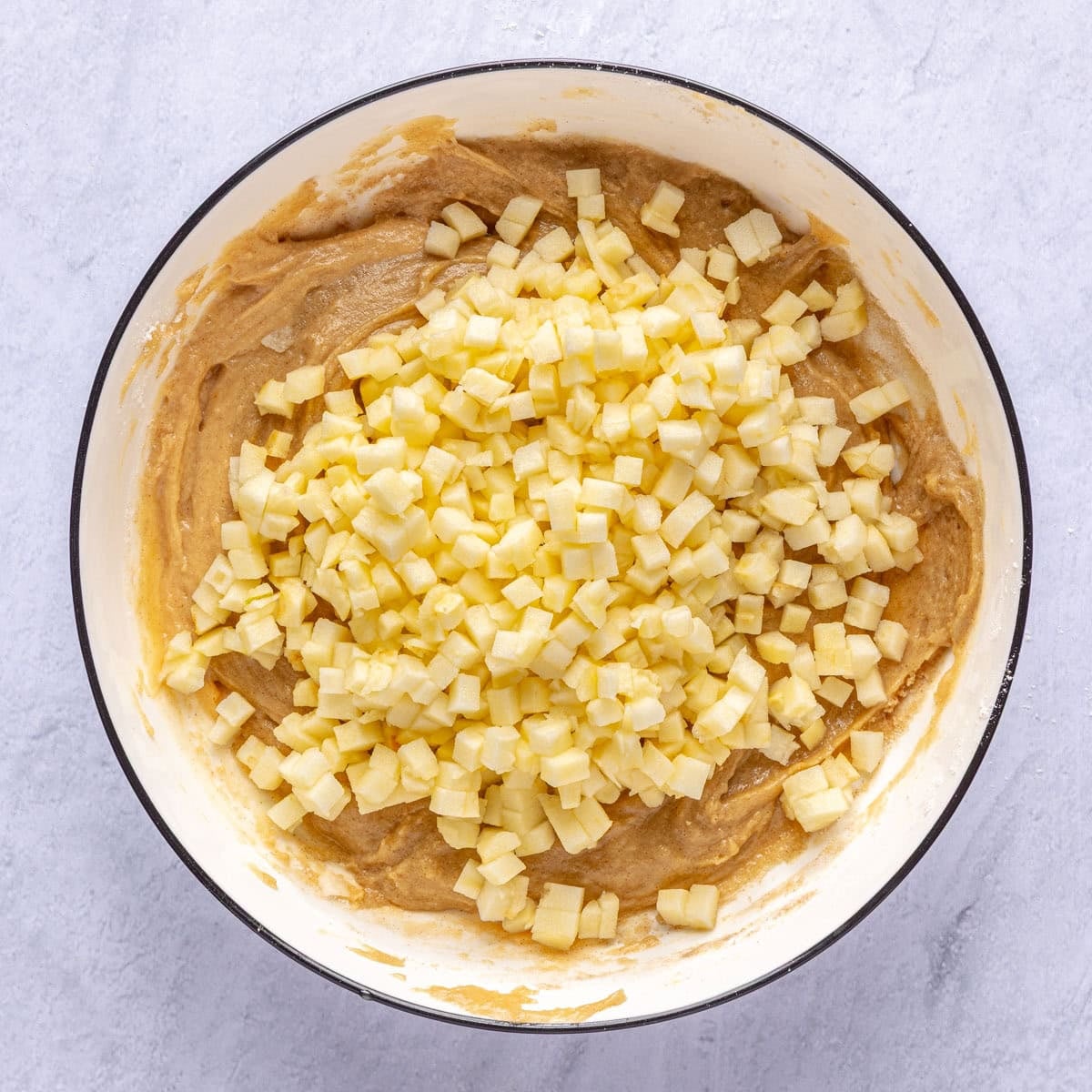 Diced apples added on top of muffin batter.