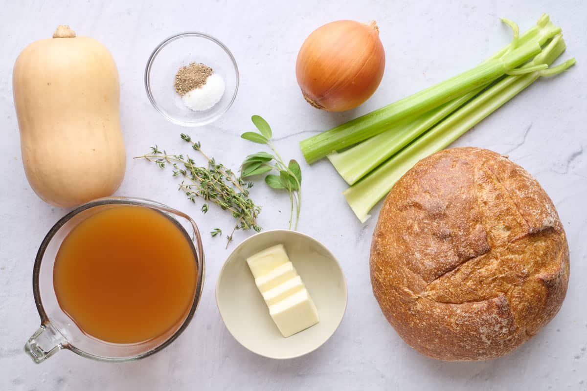 Ingredients for recipe: butternut squash, broth, salt and pepper, herbs, butter, onion, celery, and bread loaf.