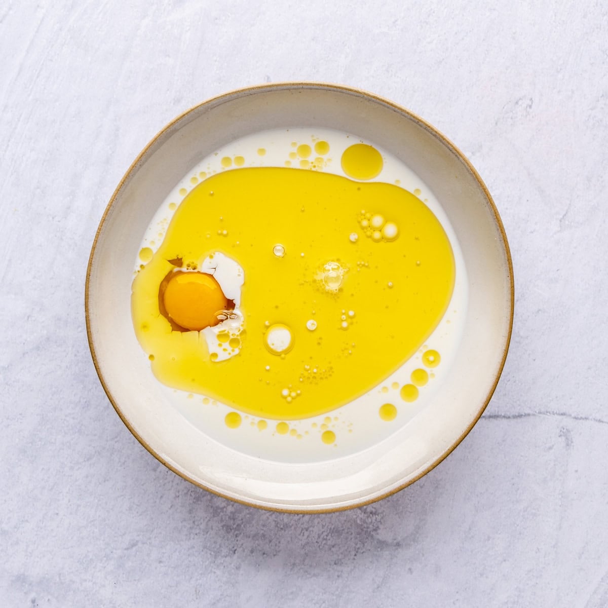 Milk, honey and a whole egg in a bowl before whisking together.