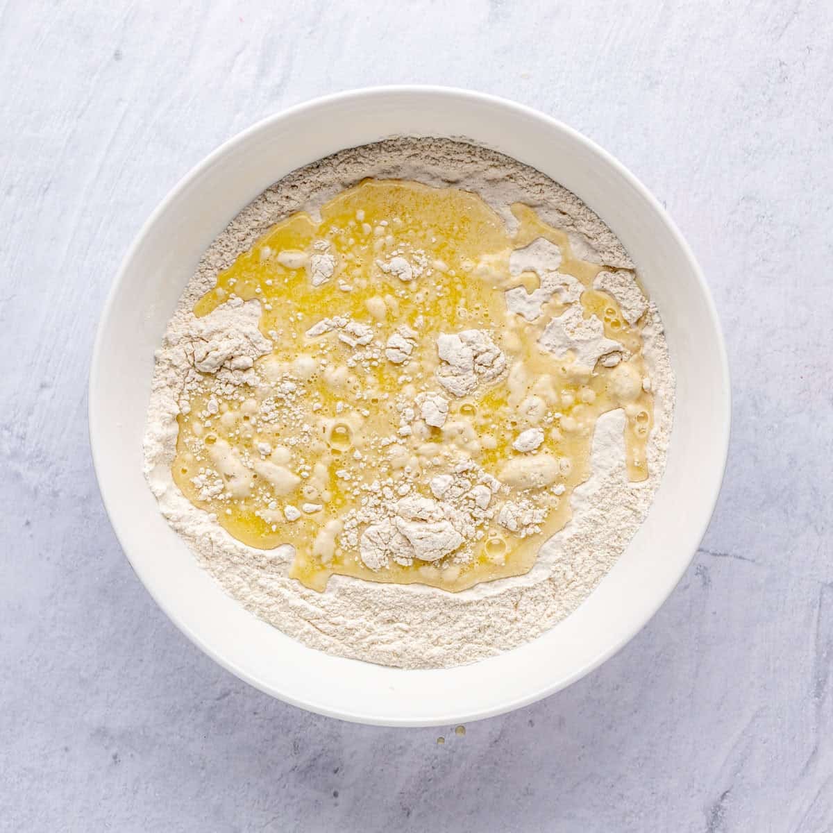 Dry ingredients in a bowl with wet mixture added on top before mixing.
