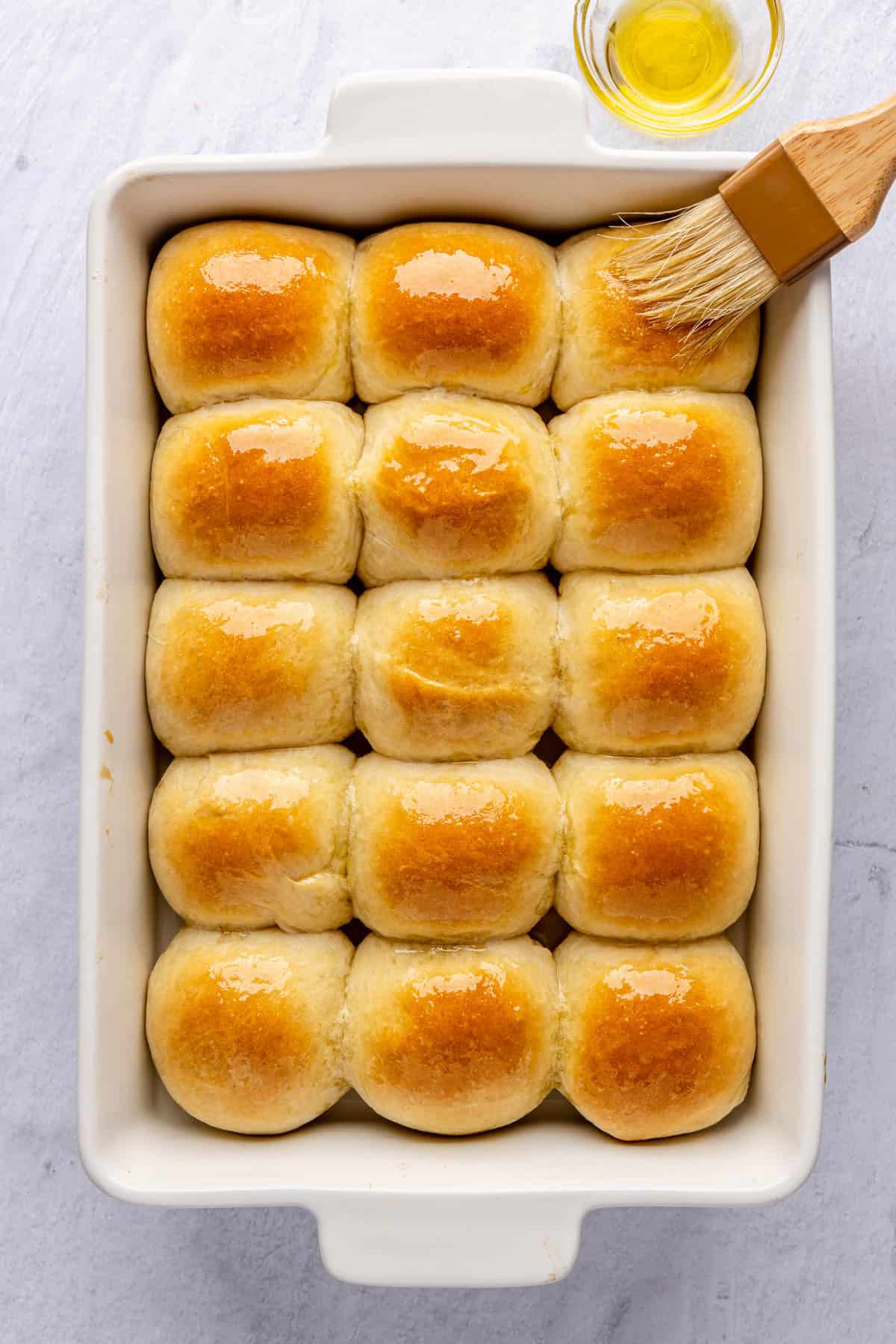 Dinner rolls after baking with oil being brushed on top before serving.