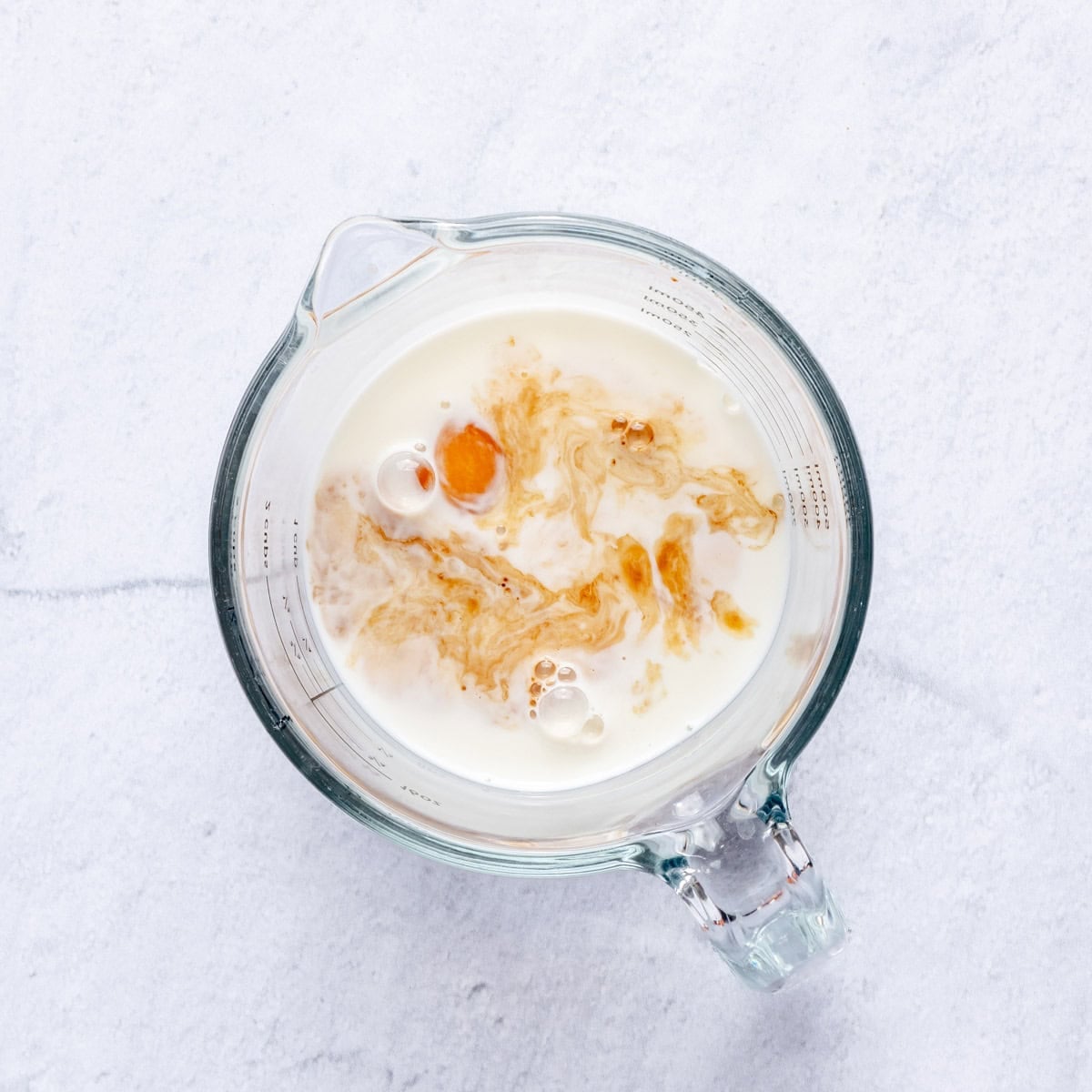 Eggs, milk, and vanilla in a measuring cup.