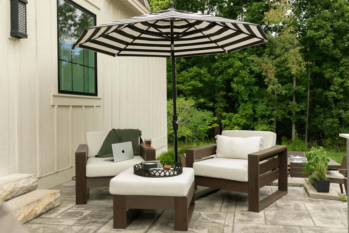 Polywood arm chairs with ottoman in cozy corner of outdoor patio