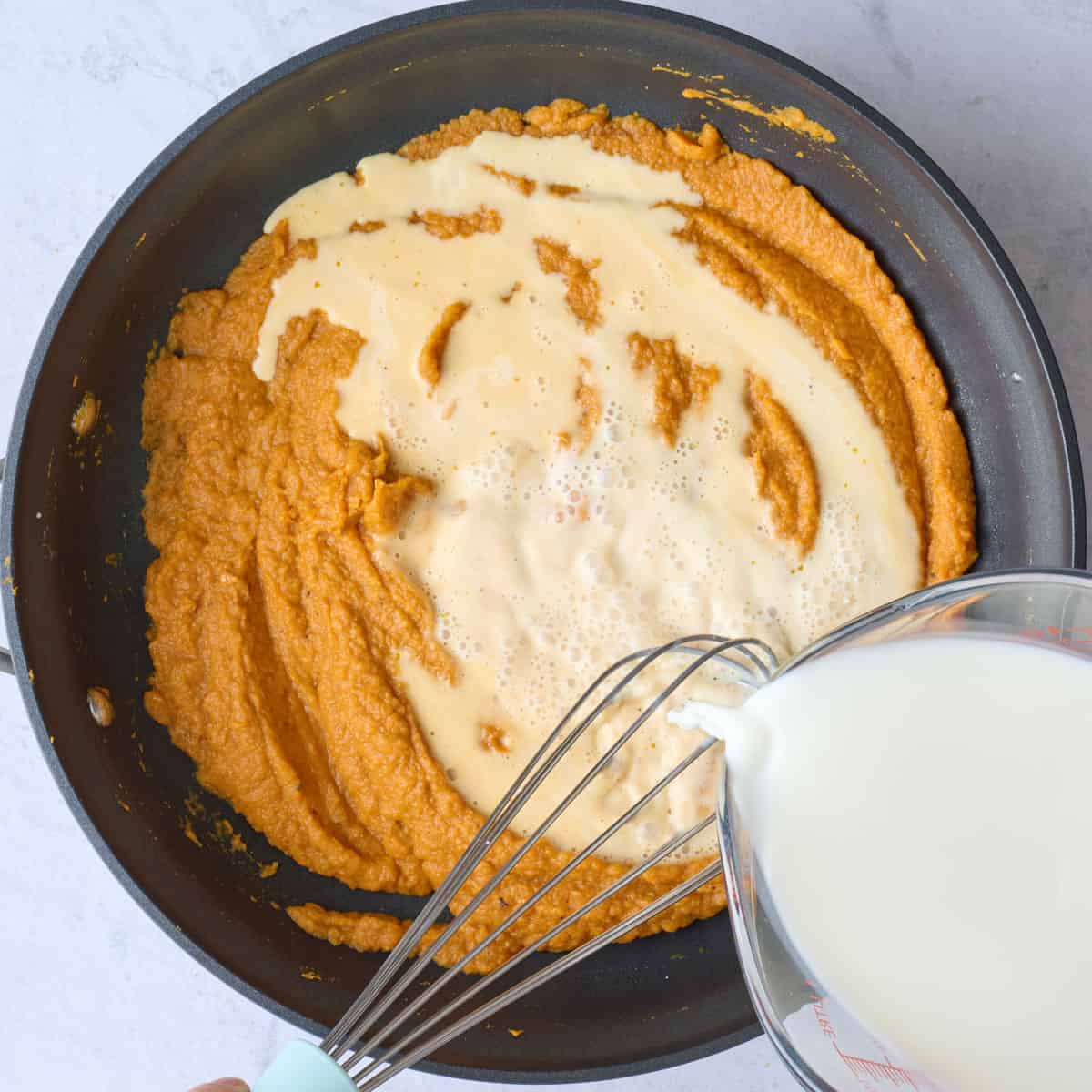 Stirring milk into pumpkin puree.