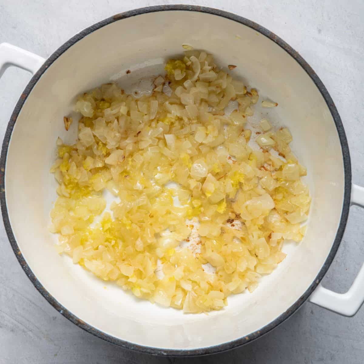 Sauteed onions in pot with aromatics.