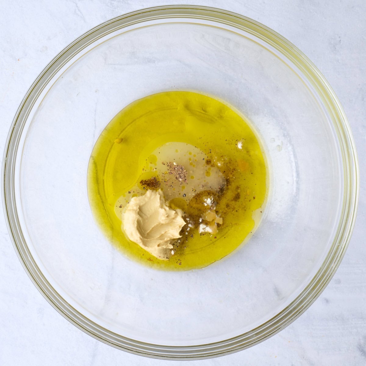 Dressing ingredients in a bowl before mixing.