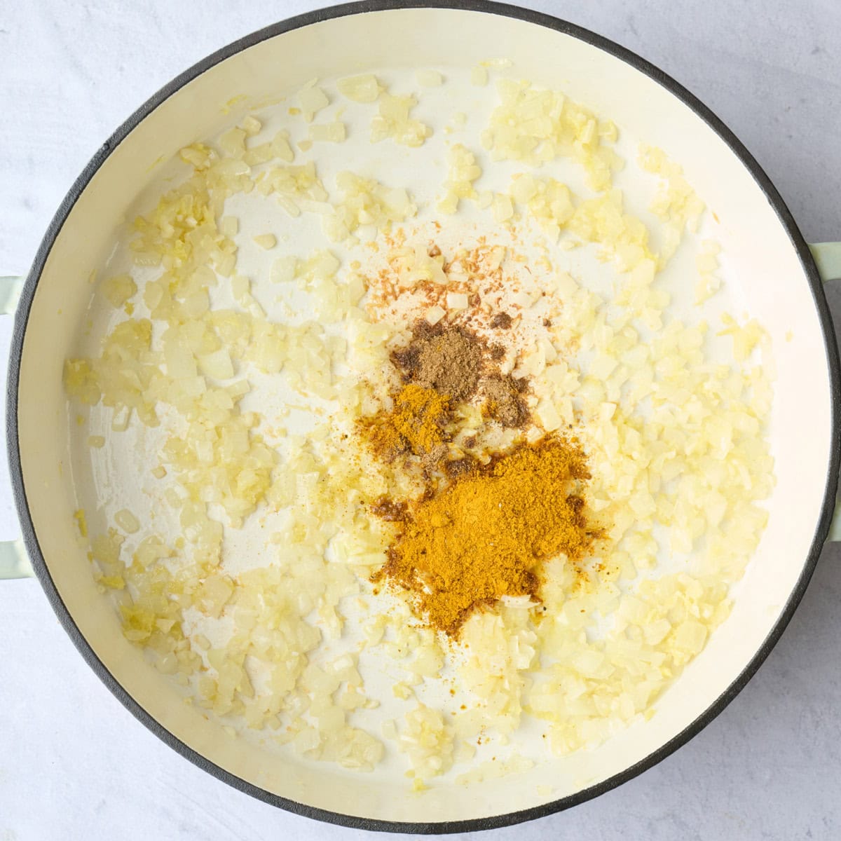 After cooking aromatics for the base of the butternut squash soup recipe in a pot with curry powder and cumin added before combining.