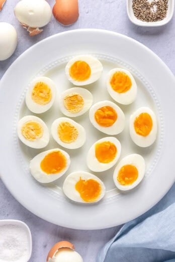 Instant pot hard boiled eggs on a plate after cutting in half at varying cook temps.