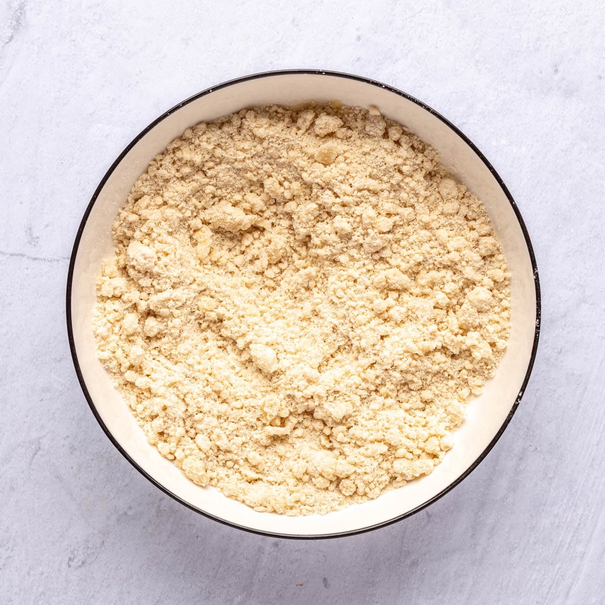 Dessert bar crust ingredients after combining until crumbly in a bowl.