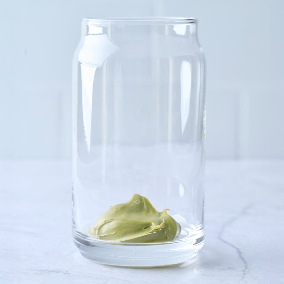 Pistachio cream in the bottom of a glass for latte recipe.