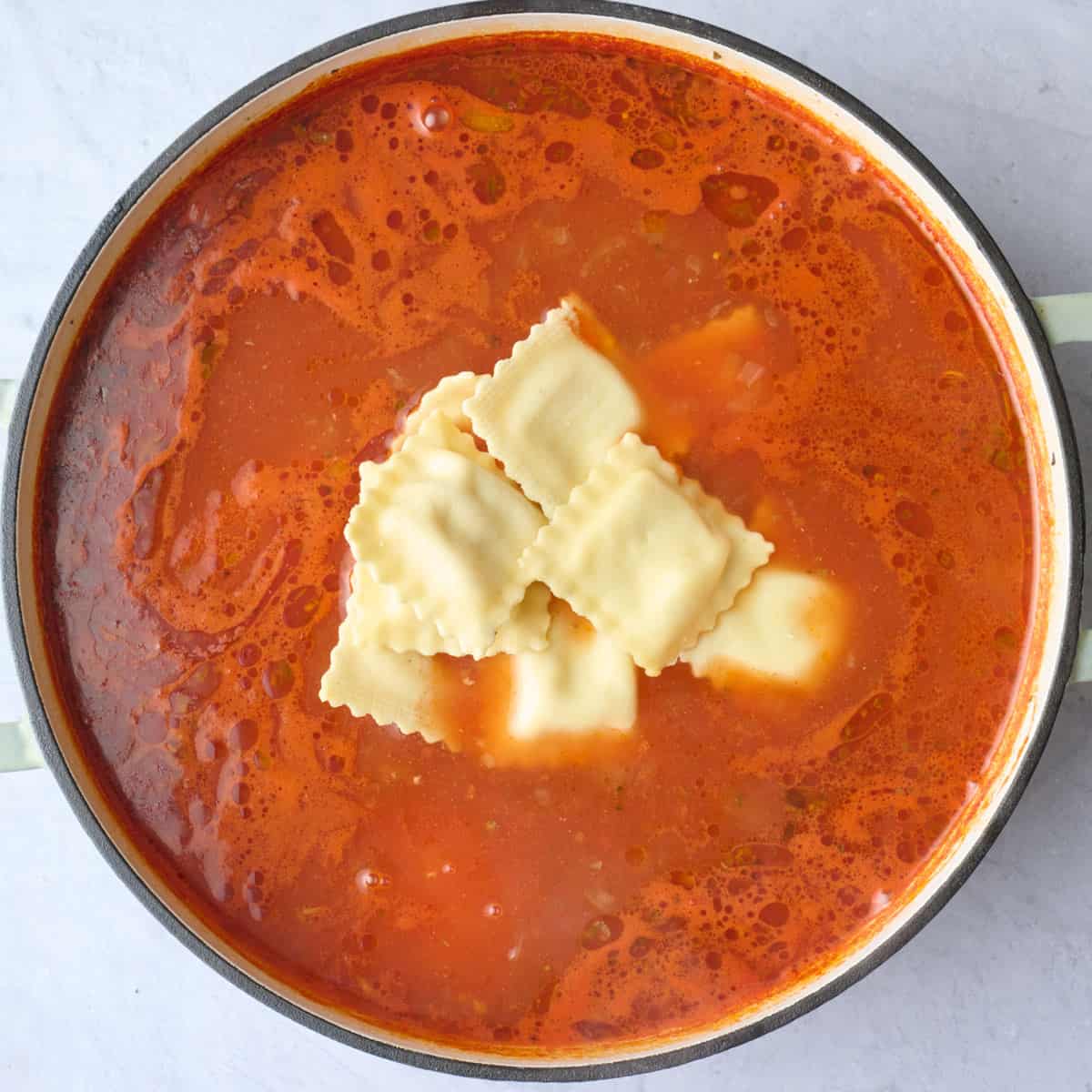 Mini ravioli added to the pot of soup before combining.