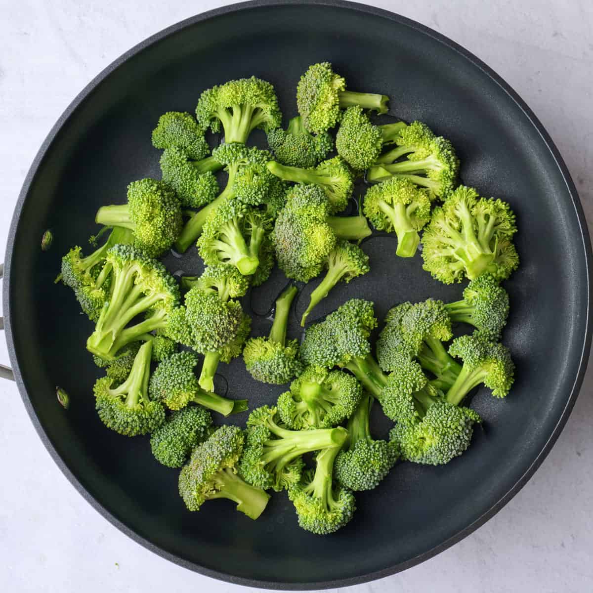 Broccoli florets in a skillet after steaming.