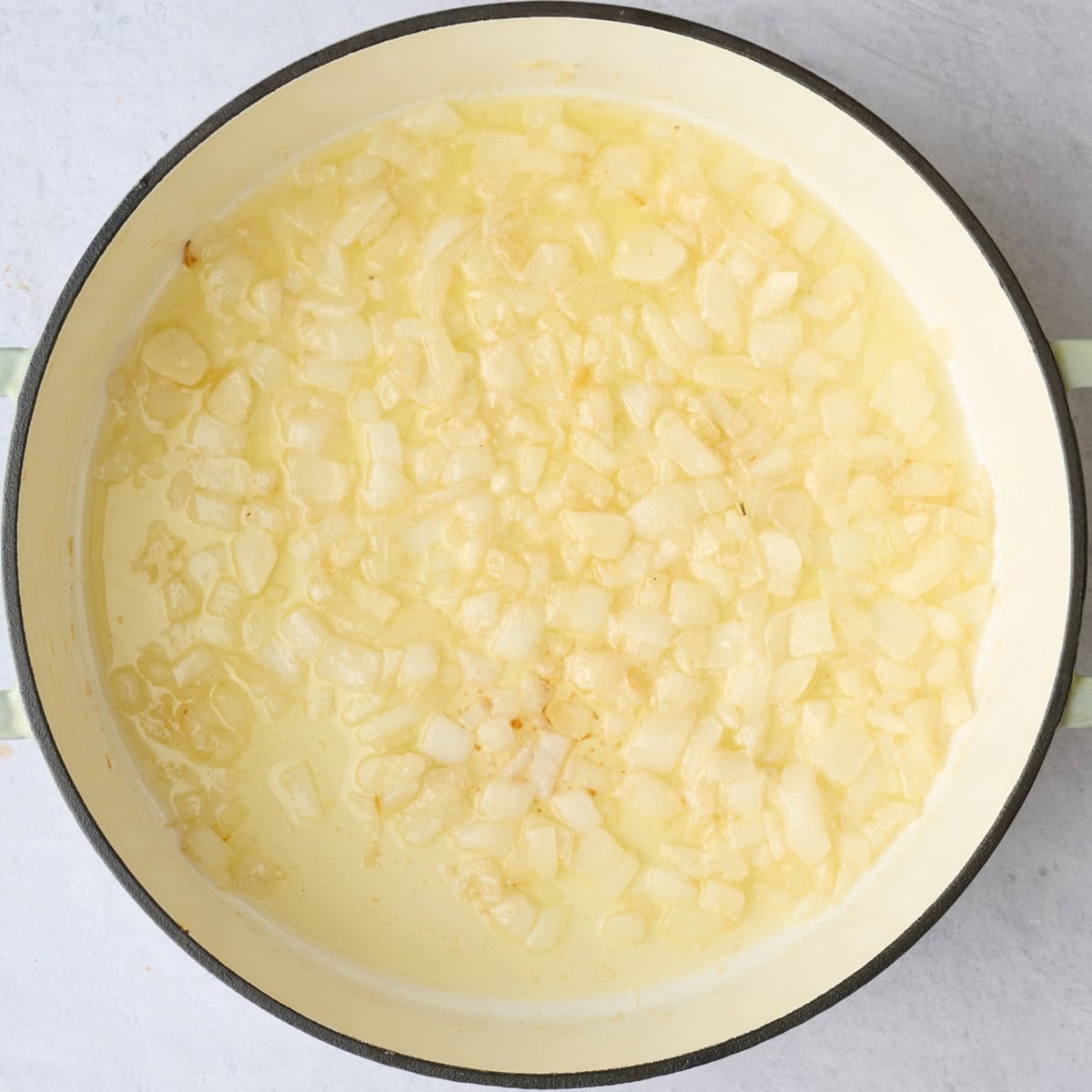 Softened onions and garlic in a pot after cooking with butter for tomato soup recipe.