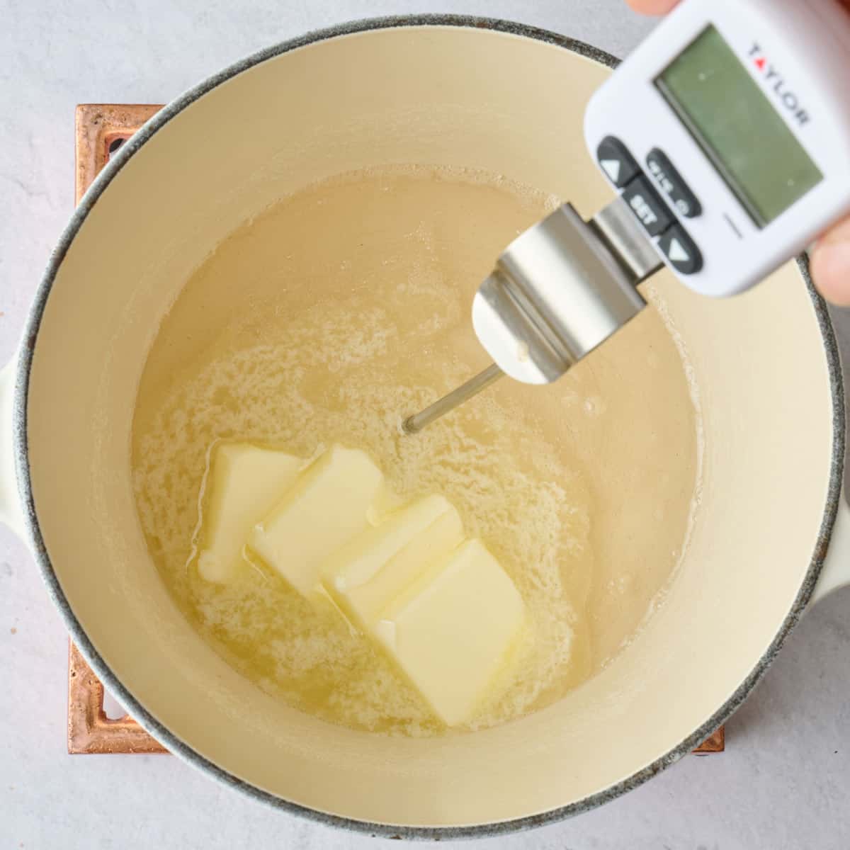 Butter added to boiling sugar with a candy thermometer dipped inside.
