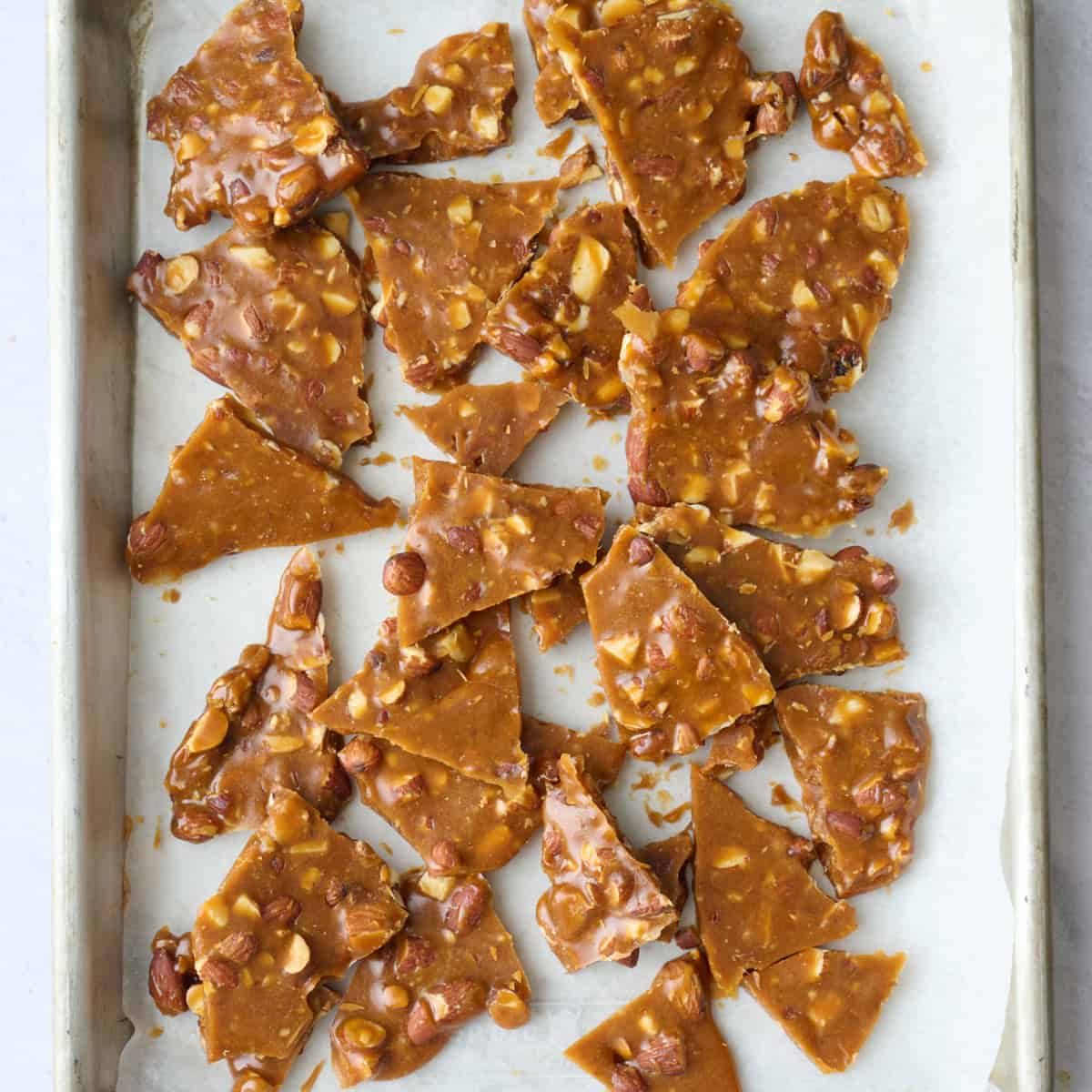 Crisp almond brittle after setting and broken into pieces.
