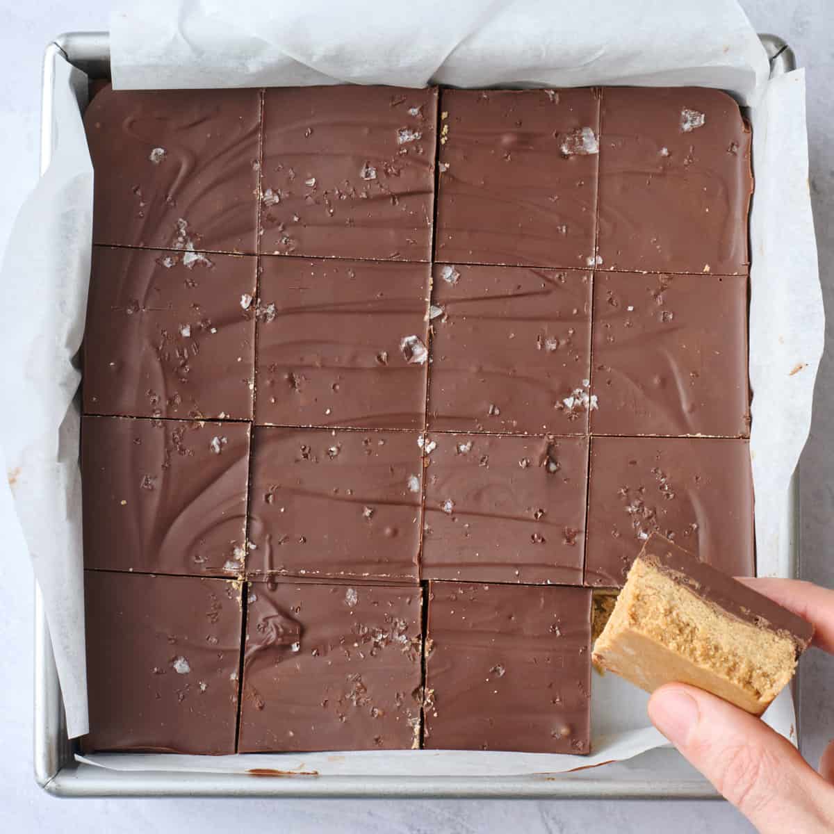 After pb bar is cut into 16 pieces with a hand holding a piece.