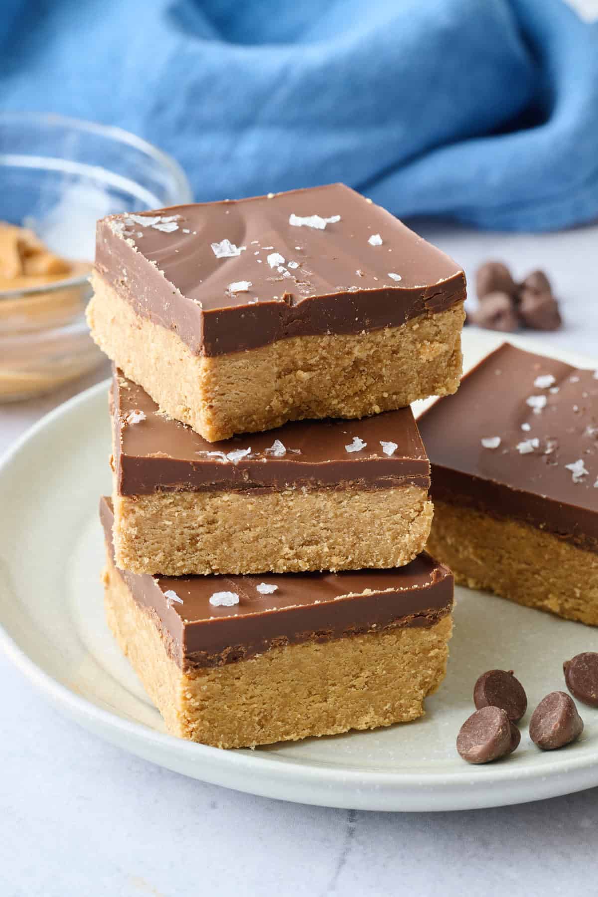 Homemade chocolate peanut butter bars stacked up to show the thick layers.