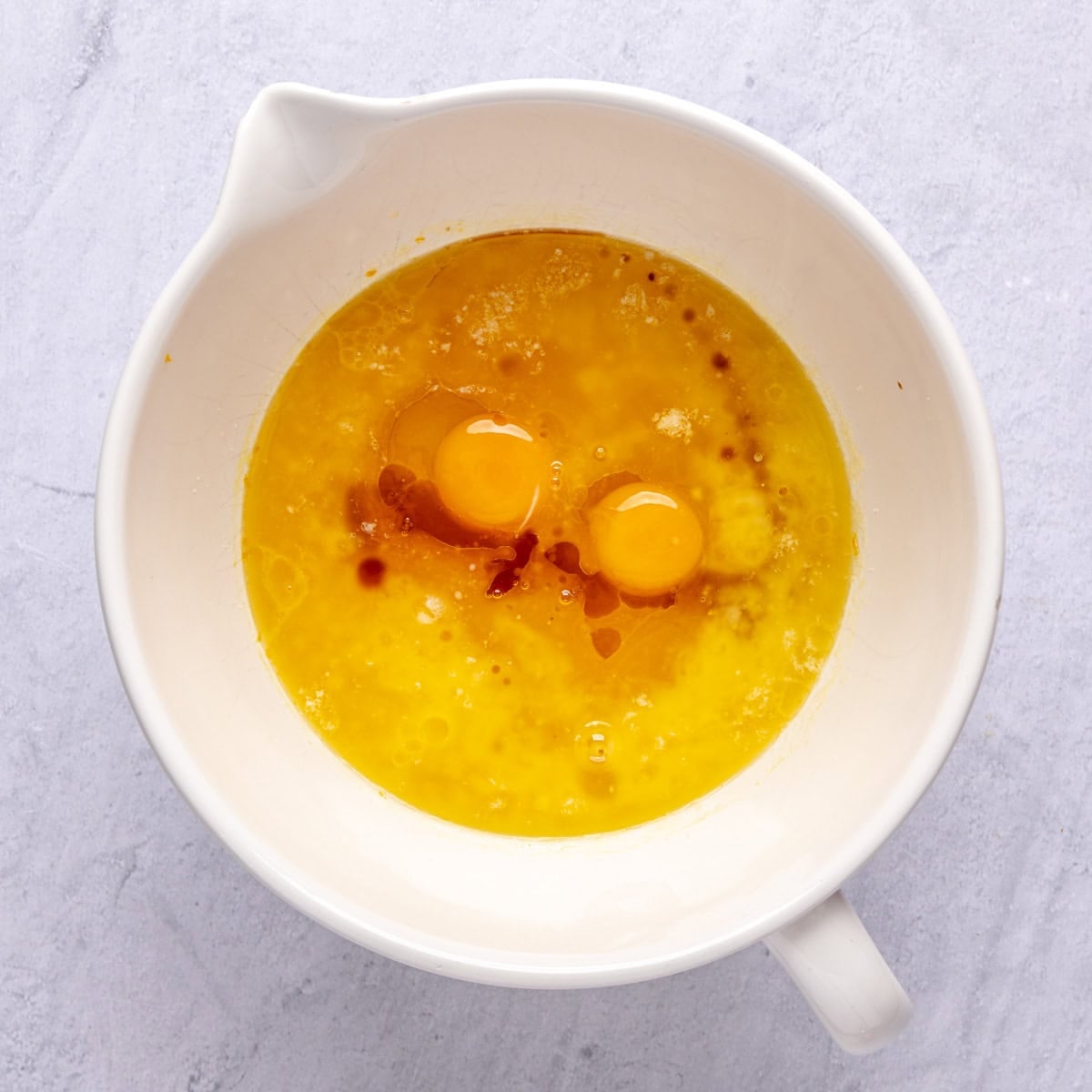 Orange juice, melted butter, eggs and vanilla added to orange infused sugar before mixing.
