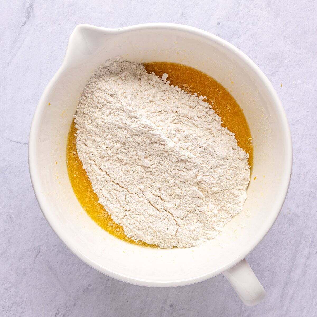 Wet ingredients for quick bread after mixing with dry ingredients added on top.