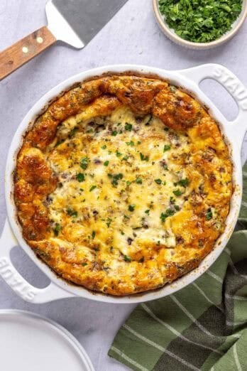 Crustless quiche in baking dish with pie spatula nearby.