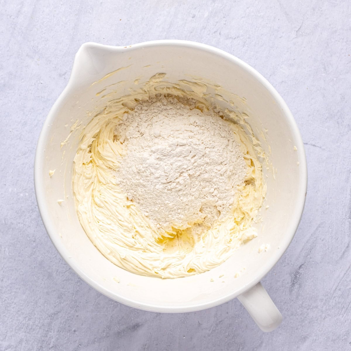 Part of the flour added to the creamed butter and sugar before combining.