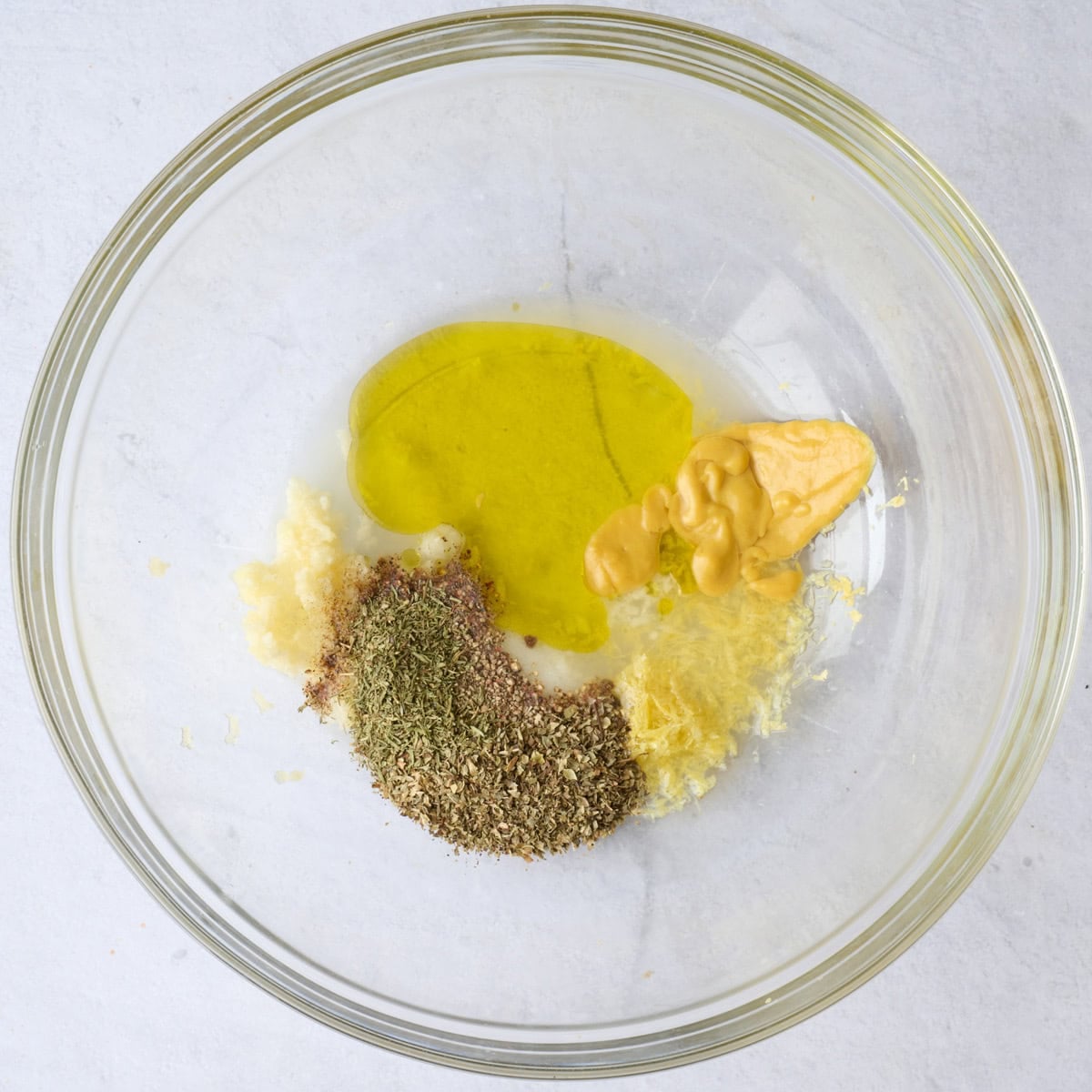 Greek marinade ingredients for chicken recipe in a bowl before mixing.