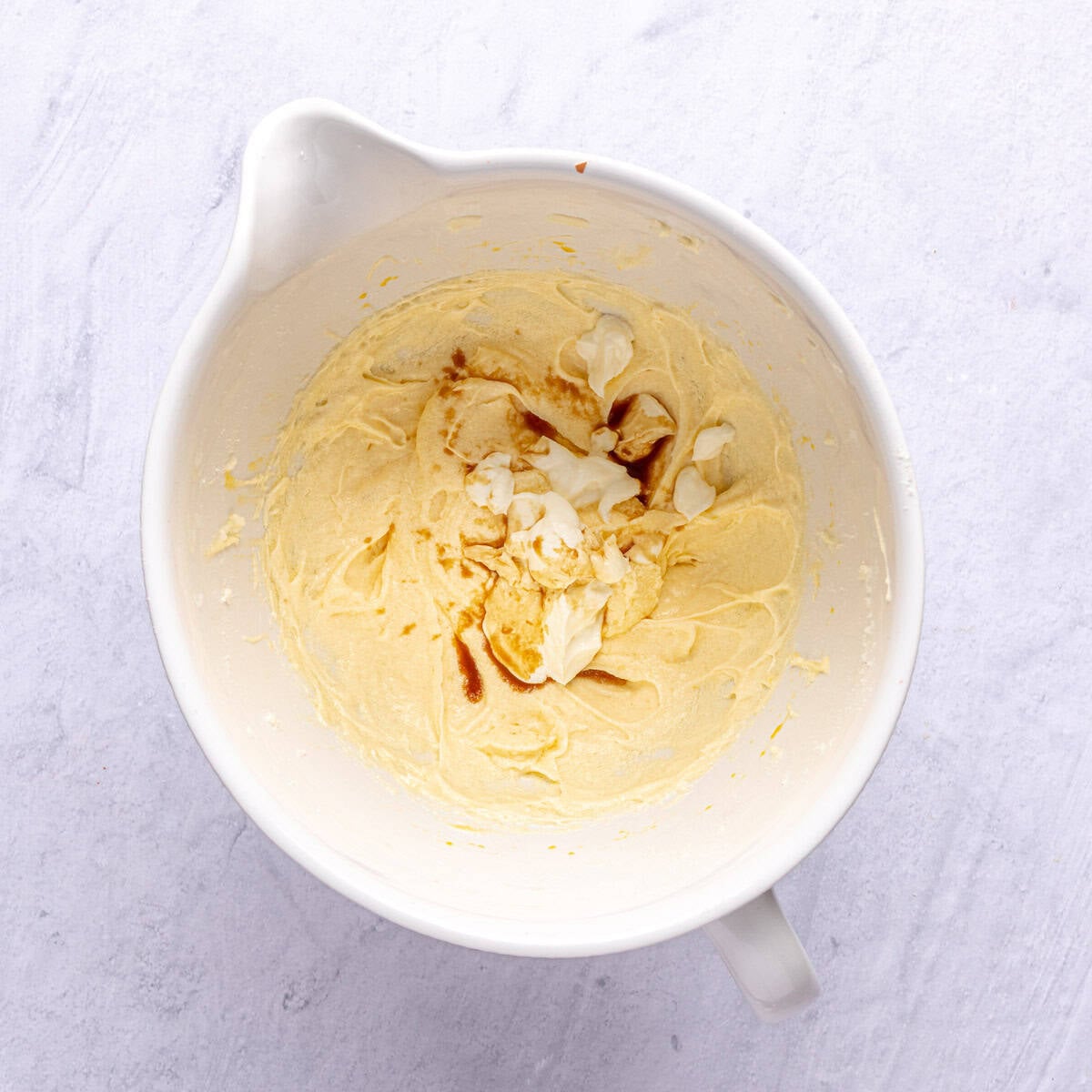 Eggs and creamed butter and sugar mixture with Greek yogurt and extracts added before mixing for sugar cookie recipe.
