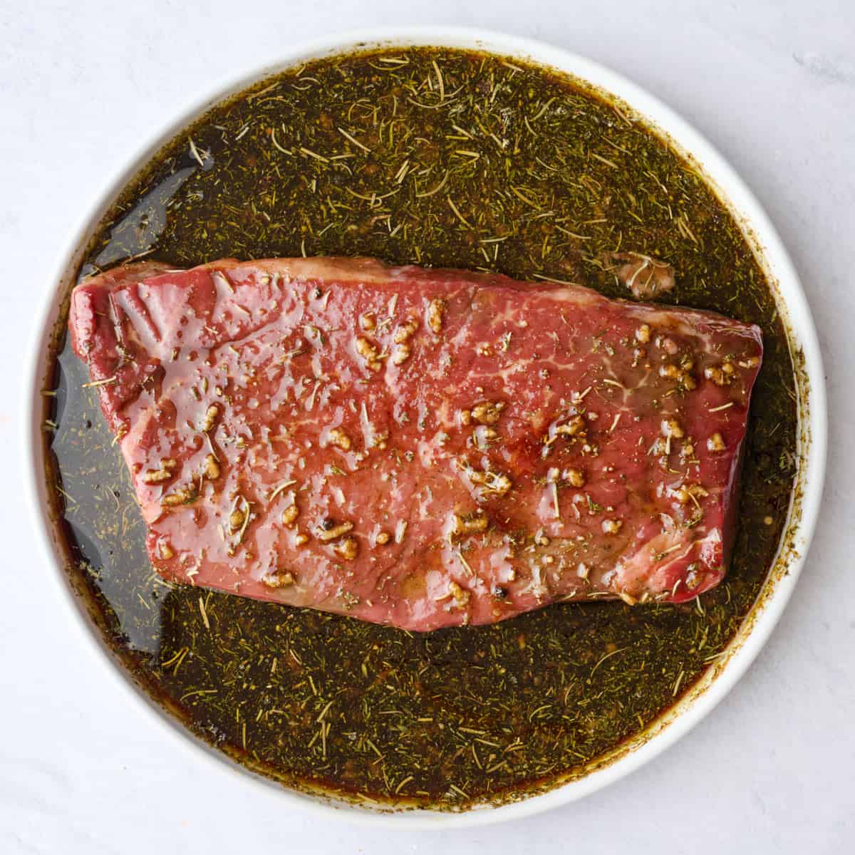 Top round steak tossed in marinade.