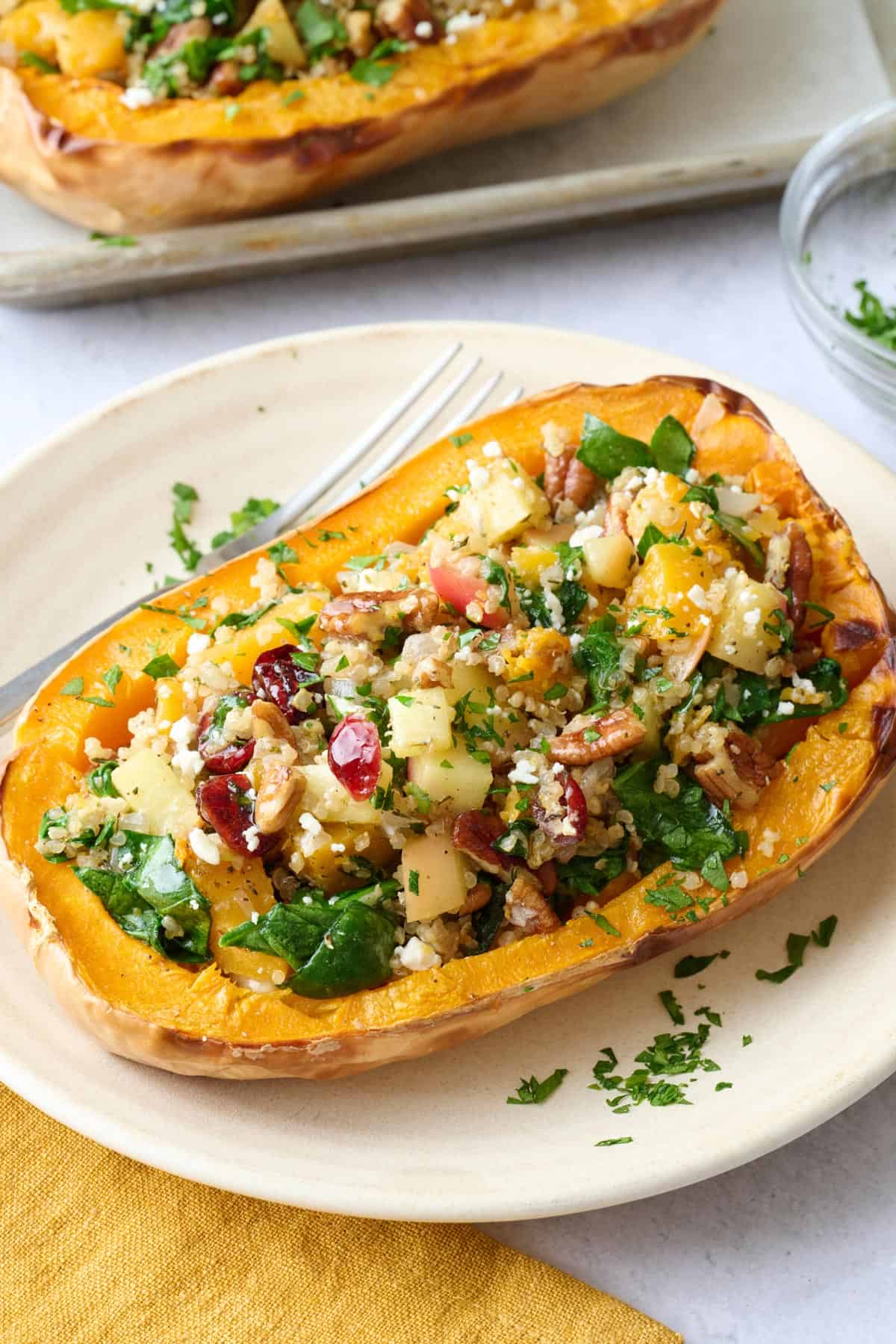 Best vegetarian stuffed butternut squash recipe filled with a quinoa, pecan, cranberry and feta filling.