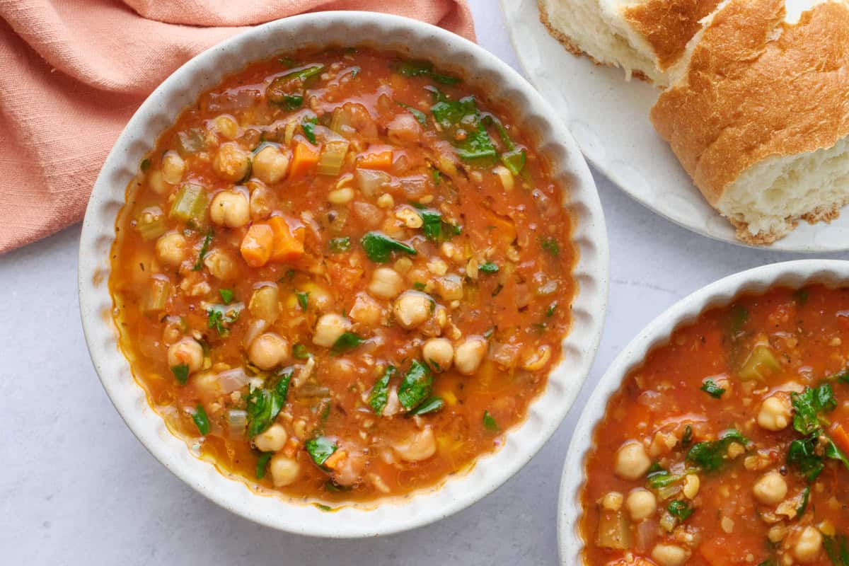 Chickpea soup recipe with spinach served in two bowls.