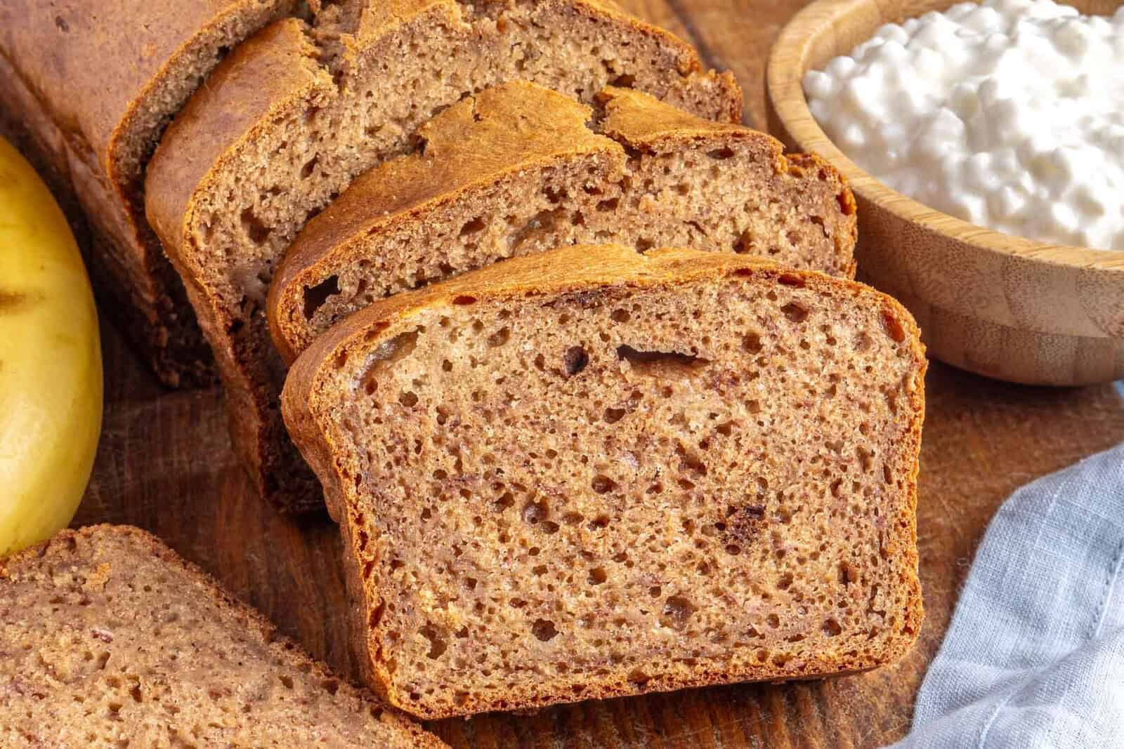Easy banana bread recipe made with cottage cheese cut into thick slices on a cutting board.