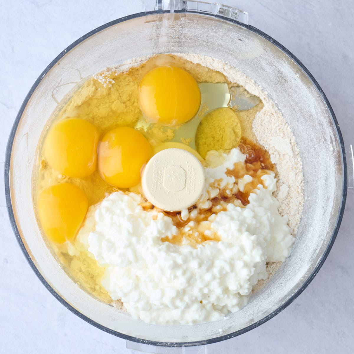 Oats flour, cottage cheese, eggs, and vanilla in a food processor before mixing.