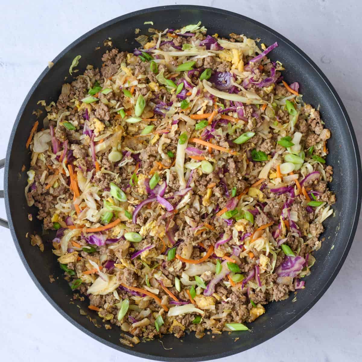Egg roll recipe after cooking and tossing together with slaw mix and sauces in a pan.