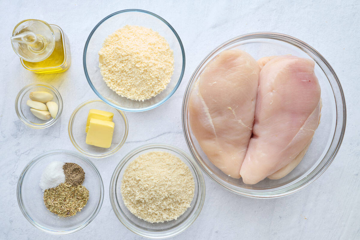 Ingredients for recipe: garlic, breadcrumbs, parmesan, seasonings, chicken breasts, oil, and butter.