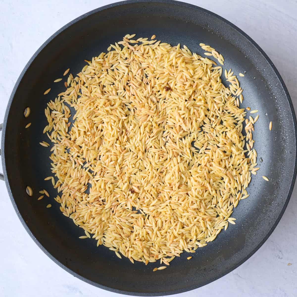 Garlic after sautรฉing in chicken drippings with orzo added and toasted.