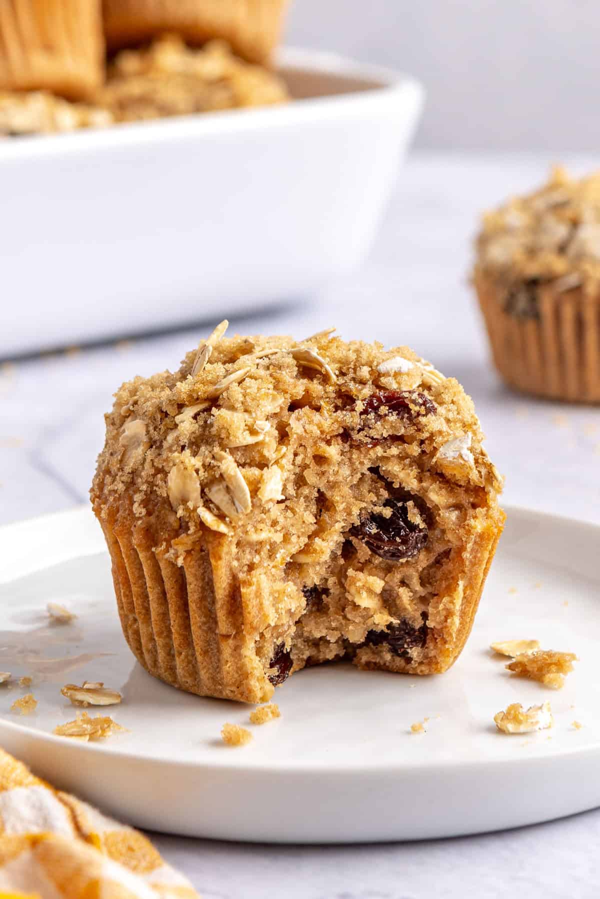 Soft oatmeal muffin on a plate with a bite taken out.