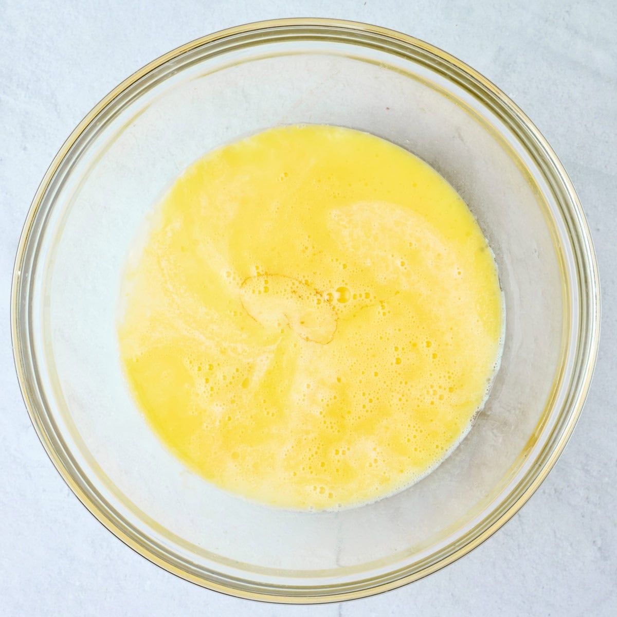 Melted butter and egg whisked together with milk, maple syrup, lemon juice and vanilla added before combining.