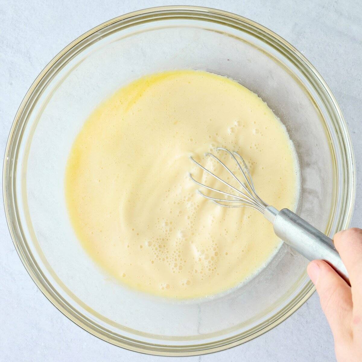 Wet ingredients for batter being whisked in a bowl.
