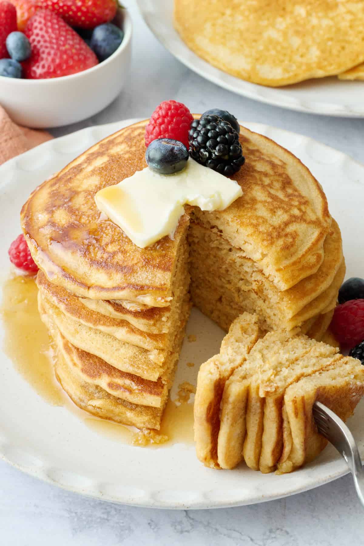 Plate of whole wheat pancakes with a bite taken out.